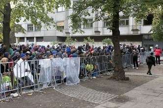 Refugees from Syria wait behind barriers in the Central Reception Centre for Asylum Seekers at the