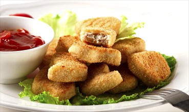 Fried chicken breast nuggets, on lettuce leaves, with tomato sauce, horizontal, no people,