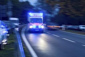 Emergency doctor with blue lights on duty on a country road, ambulance, rescue service, German Red