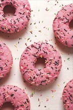 Donut with strawberries, in pink glaze, confectionery decoration, top view