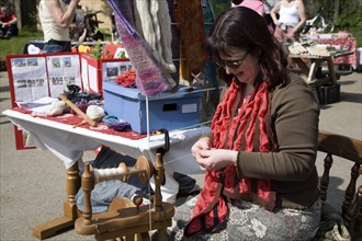 Woman demonstrating traditional spinning at a country craft event, Shottisham, Suffolk, England,