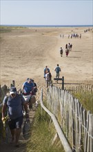 People walking across wide sandy beach at Holkham, north Norfolk coast, England, United Kingdom,