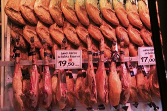 Meat stall butcher selling Jamon Iberico joints, Mercado de San Miguel market, Madrid city centre,