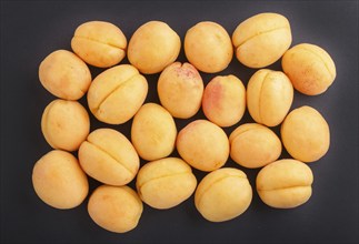 Apricots on black background, top view, flat lay