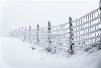 Snow-covered and icy fence, winter in Sauerland, Hochsauerlandkreis, at Kahler Asten, near