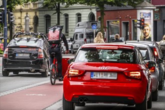 Bicycle lane, marked red, between 2 lanes for vehicles, city centre traffic, Dortmund, North