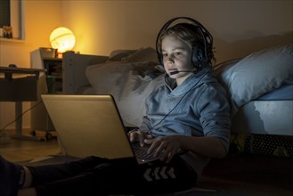 Boy, at home on the computer, laptop, in the children's room, playing a game, chatting with other