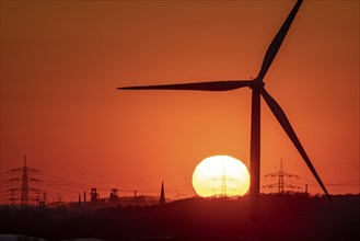 Wind turbine of the Emschergenossenschaft, view to the west, in Essen, sunset, behind the blast