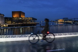 Cyclists on the Inderhavnsbroen cycle and footpath bridge, across the harbour, at night, at Nyhavn,