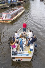 Plastic Whale boat in a canal in Amsterdam, passengers fish plastic waste out of the canals, tour