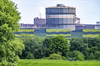 The ThyssenKrupp Steel steelworks in Duisburg-Beeckerwerth, cyclists on the Rhine dyke, green Rhine