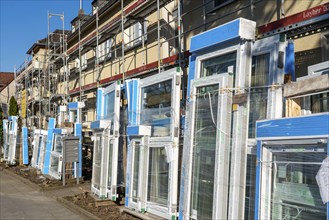 Energy-efficient refurbishment of residential buildings, older apartment block is scaffolded, gets