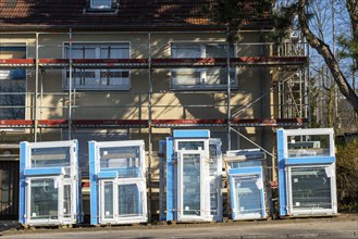 Energy-efficient refurbishment of residential buildings, older apartment block is scaffolded, gets