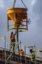 Concrete work, at dusk, on a large construction site building a residential and commercial complex,