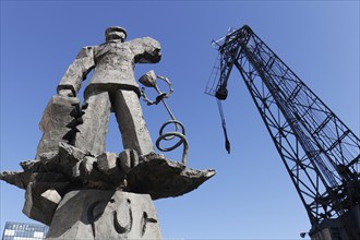 Hans Albers statue, bronze sculpture by sculptor Jörg Immendorf, and old harbour crane, Düsseldorf