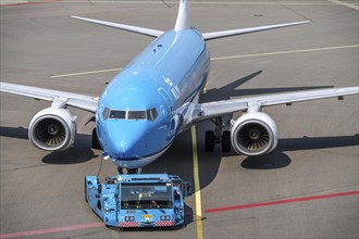 Boeing 737-800 from KLM, being driven from the terminal onto the apron, pushback, with an aircraft