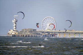 The pier and Ferris wheel at Scheveningen beach, strong swell, windsurfers, kitesurfers,