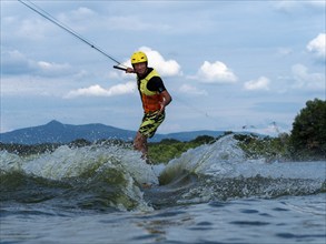 Man jumping with wakeboard, water sports, water skiing and wakepark