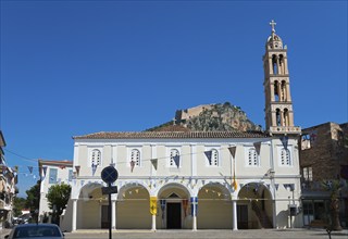 Traditional church with bell tower and mountain fortress under a bright blue sky, Holy Metropolitan