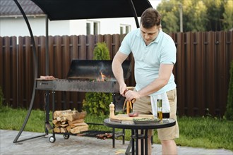 Man making barbecue outdoor on grill