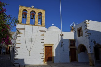 Agios Ioannis Prodromos Church, A church with a light-coloured stone bell tower and white walls on