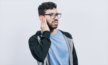 Person with ear pain, on isolated background, Suffering man massaging his ear isolated, concept of