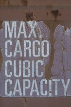 Close-up of maximum cargo cubic weight holding capacity indicated on outside of shipping container,