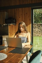 Woman looking for a recipe in internet sitting at the kitchen table