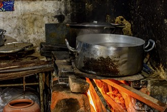 Rustic wood stove preparing food inside the kitchen of a poor house in Brazil, Minas Gerais,