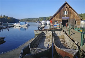 Harbour with boats and wooden hut, surrounded by calm water and nature, Eldenburg, Tourism, Waren