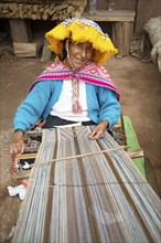 Peruvian woman in traditional traditional costume at the loom, woman's cooperative Comunidad de