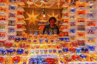 Saleswoman in a stall for tea lights at the Christmas market at St Stephen's Cathedral,