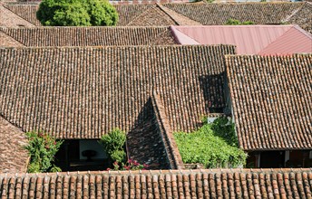 Top view of old terracotta tiles on the roof of some houses. Old tile roofs of houses in Granada,