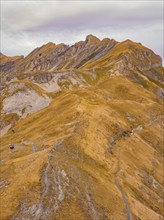 Rough mountain terrain under a cloudy sky with a path through autumnal rocks, Alpen Tower,