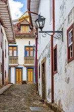 Alley with old colonial houses and stone paving in the historic city of Ouro Preto in Minas Gerais,