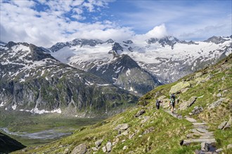 Mountaineer on hiking trail in picturesque mountain landscape, mountain peak with snow and glacier