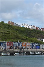 Colourful lobster shacks on the promenade in the lowlands, boats, offshore island of Heligoland,