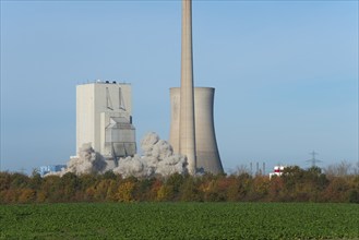 Industrial plant with swirling dust cloud, surrounded by autumnal landscape, blasting of the ash