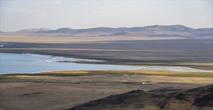 Mountain landscape with Lake Song Kul, view of yurts and horses on the lakeshore, Naryn region,