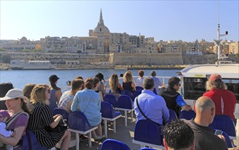 People onboard ferry boat crossing harbour from Sliema to Valletta, Malta, Europe