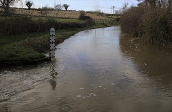 River Deben flooded road with depth measure, Marlesford, Suffolk, England, UK