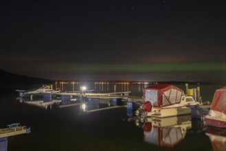 Northern lights (aurora borealis) shine on a starry night over Lake Plau, Ganzlin,