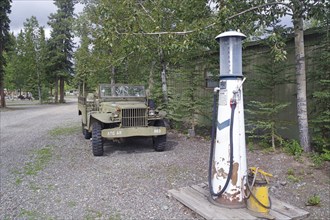 Old US Army jeep at an abandoned petrol pump, surrounded by forest, former army camp, Yukon,