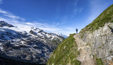 Mountaineer on a hiking trail, view of high alpine mountain landscape with glacier Glacier du Tour,