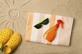 Drawing on the sand, sun and waves, sunglasses, with an orange bottle, yellow rubber slippers,