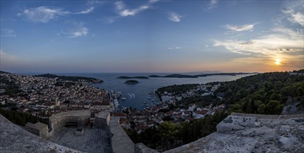 Panoramic view of a coastal town with a busy harbour and hills at sunrise, Hvar, Dalmatia, Croatia,