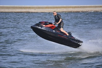 Man on jet ski, water scooter, jumping on Baltic Sea, Swinoujscie, Western Pomerania, Poland,