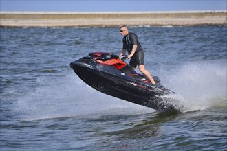 Man on jet ski, water scooter, jumping on Baltic Sea, Swinoujscie, Western Pomerania, Poland,