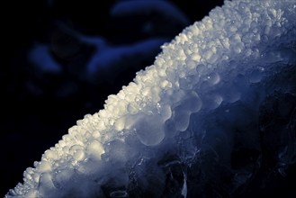 Close-up of frozen drops with blue lighting in the dark