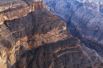 View from the Al Hayl mountain plateau into the rugged Wadi Nakhar of the Grand Canyon of Oman,